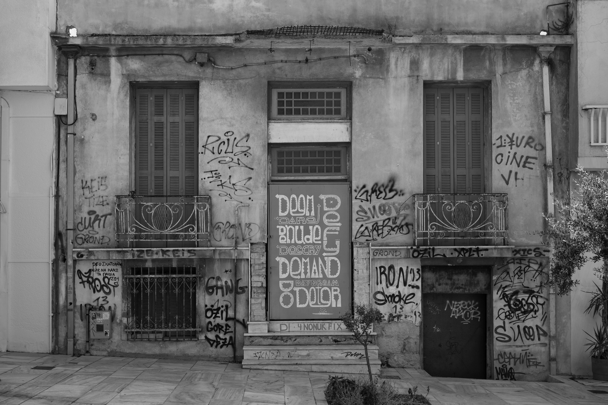 A house in Athen, near Acropolis, with a graffito on the door: deem – defy – dare – denude – descry – demand — do – daydream – deter.
