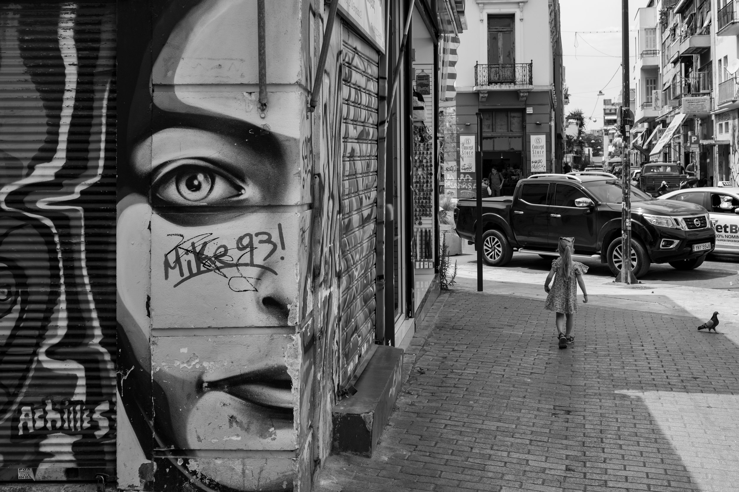 A huge graffiti by "Achilles" with a human head that looks strait at you. And my daughter walking on the street besides it.