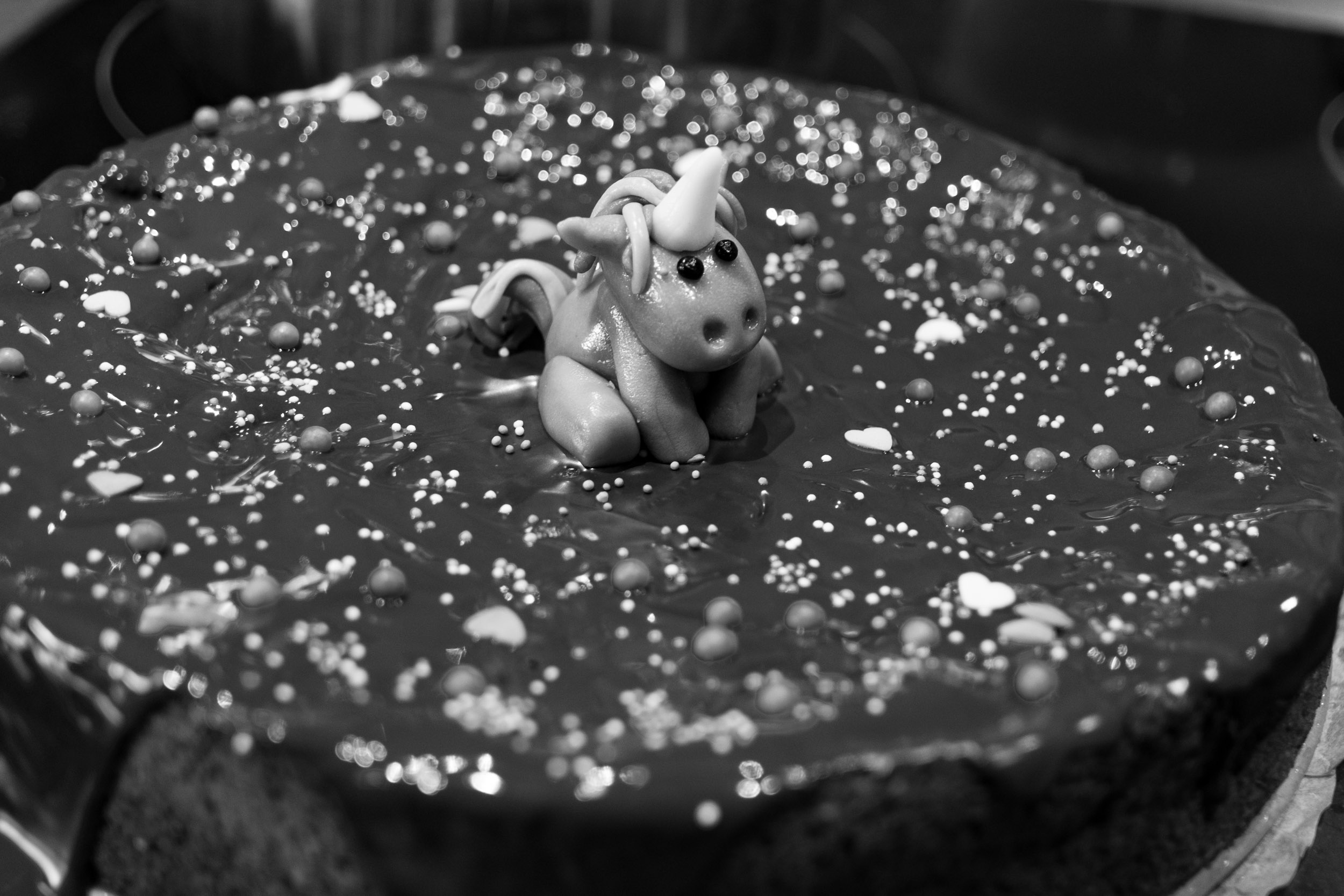 A fondant unicorn sitting on top of a chocolate cake I baked for my daughters birthday.