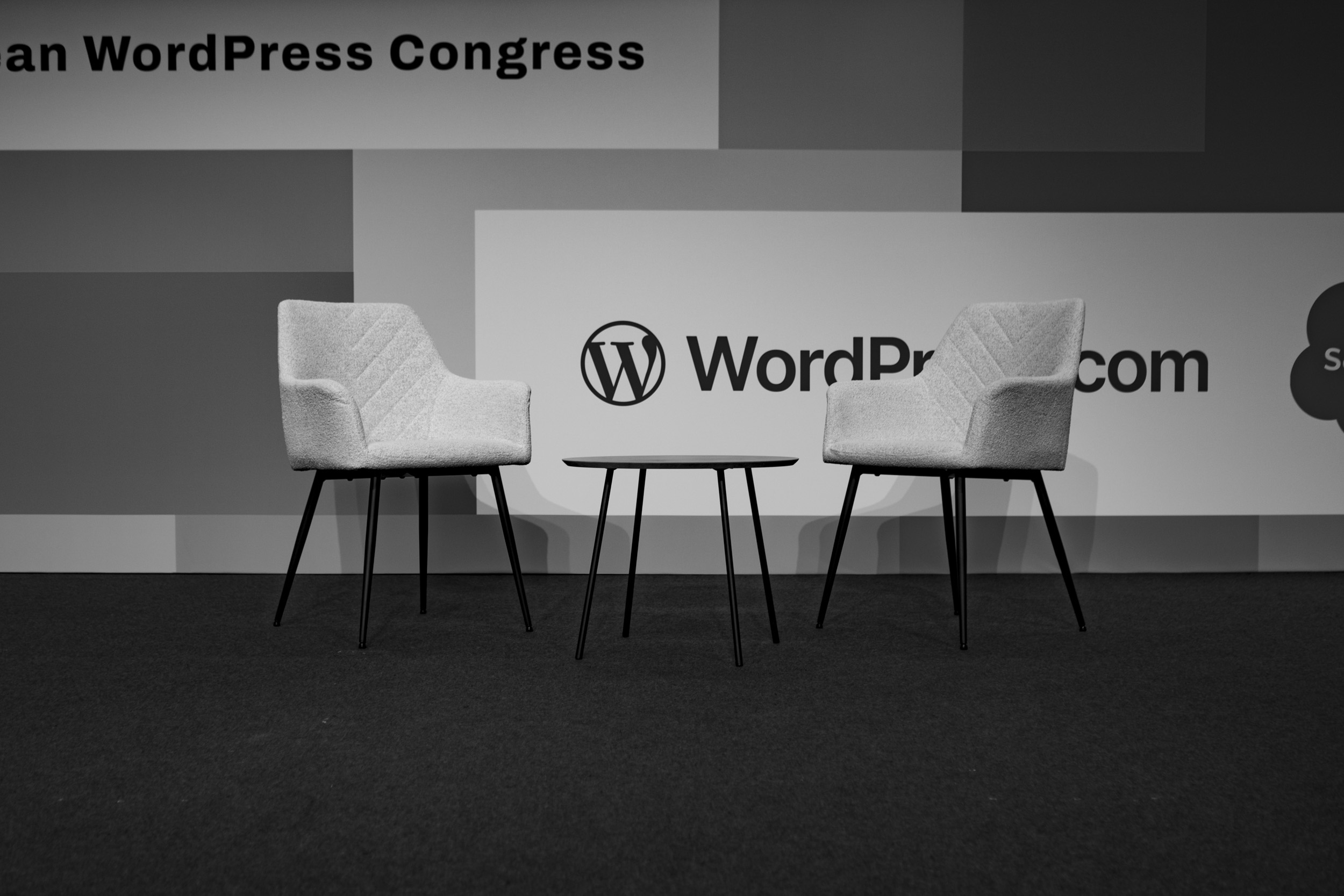 Empty chairs on the main stage, waiting for Mary Hubbard and Matt Mullenweg before their "Fireside Chat" at the end of WordCamp Europe 2025.