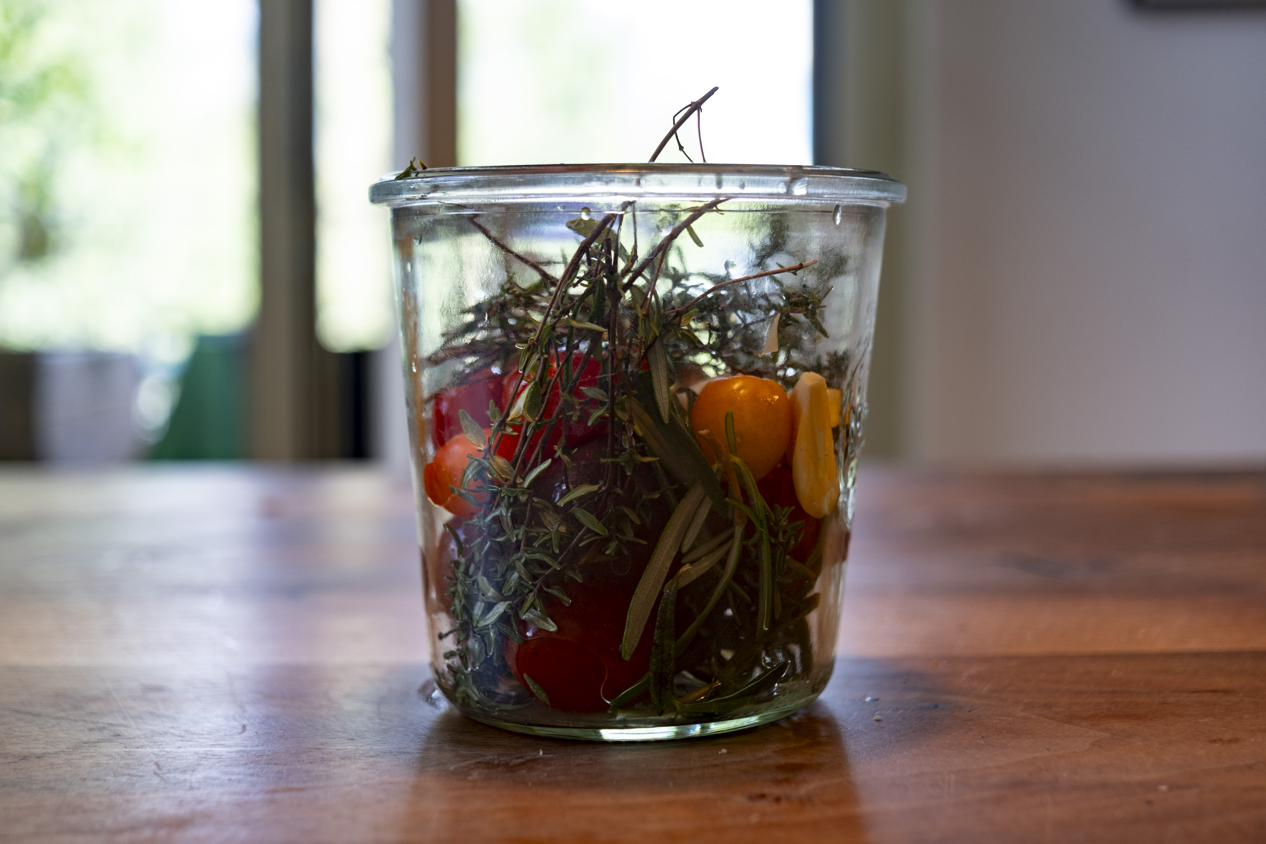 Cherrytomatoes and some herbs from our balcony, about to be pickled with apple vinegar.