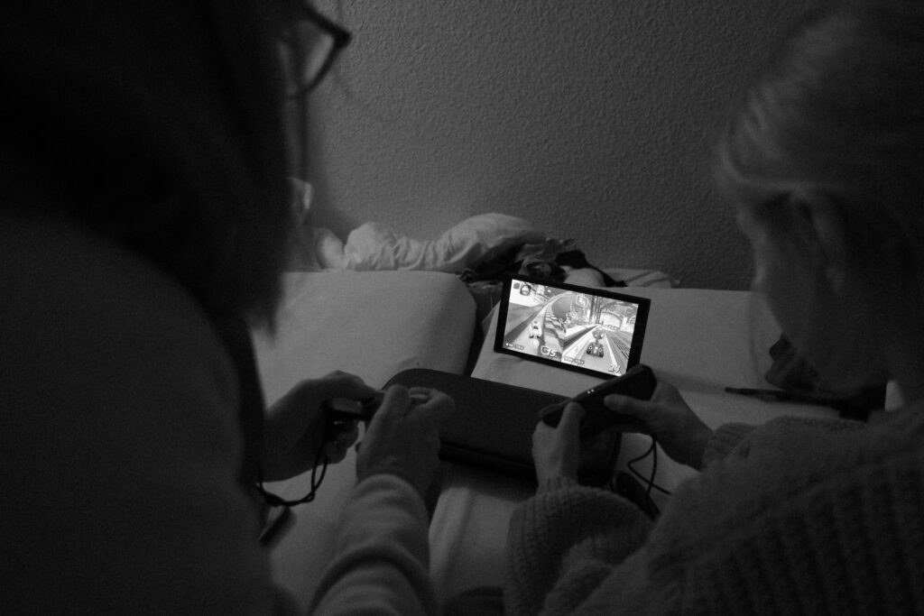My Family sitting on the bed and playing Mario Kart World on the Nintendo Switch 2 we bought for Christmas.