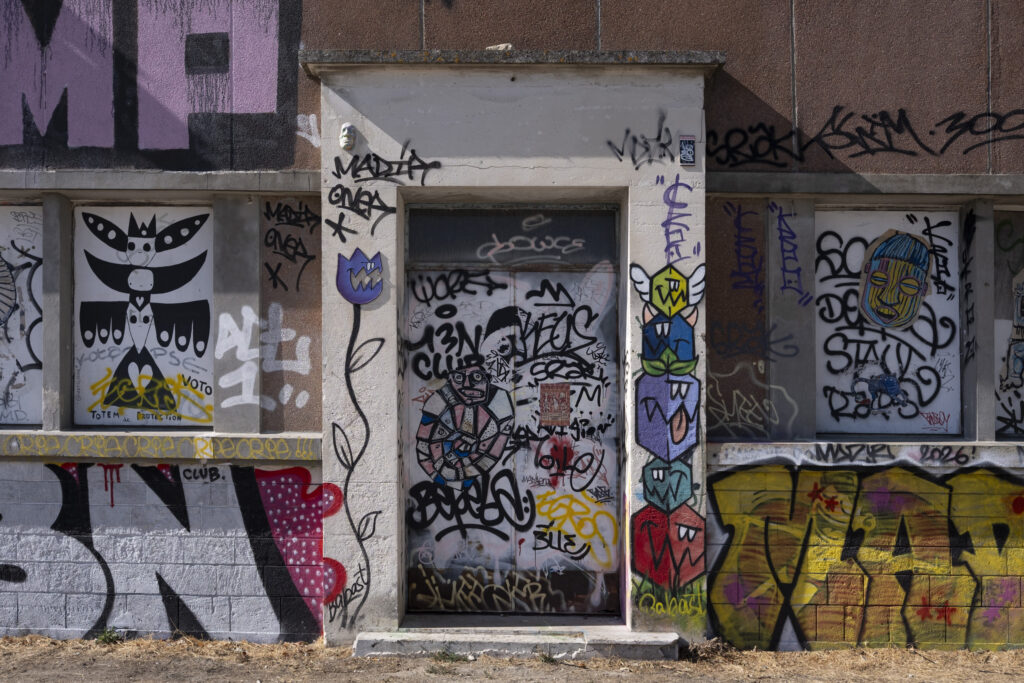 A door and windows covered in colorful graffiti, near the harbor of La Rochelle.
