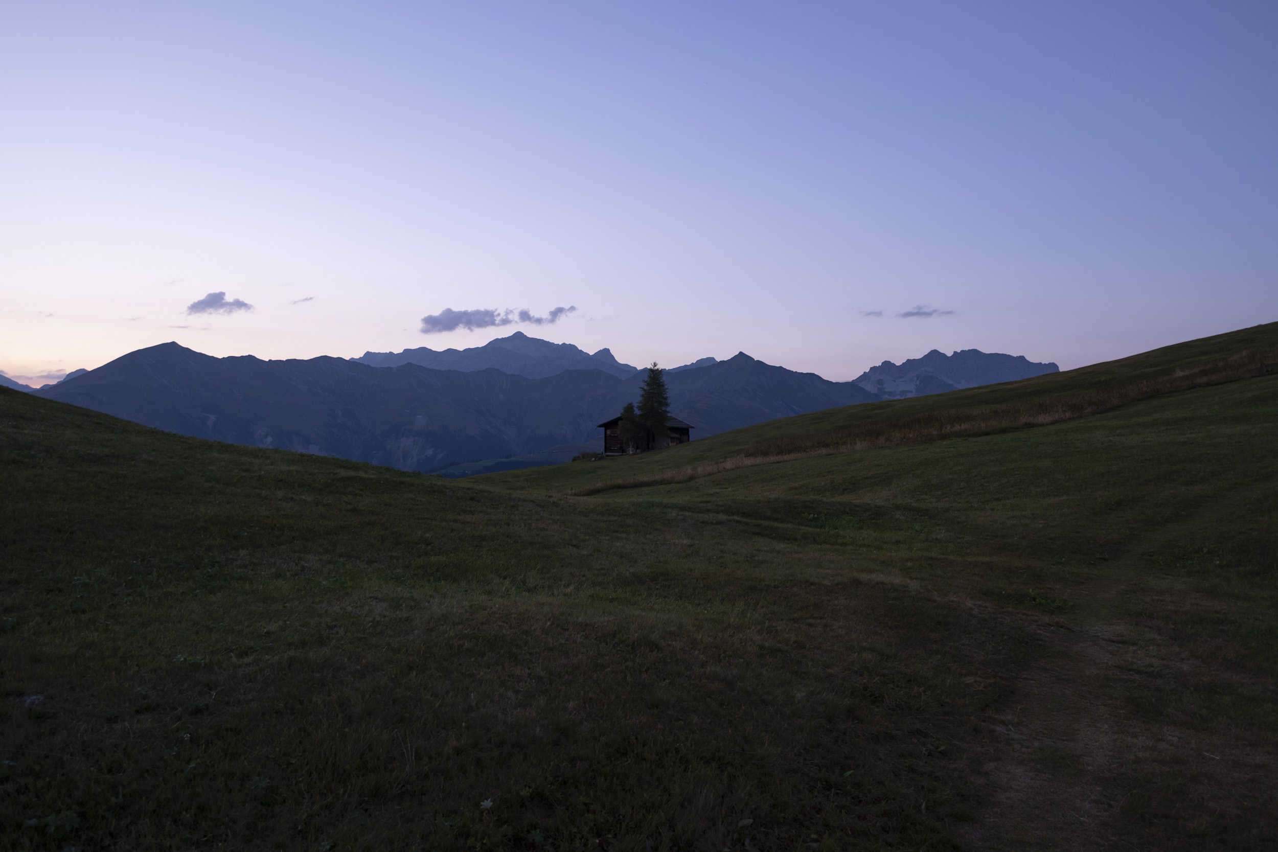 View of the Maiensäss in beautiful evening light with the mountains behind it.